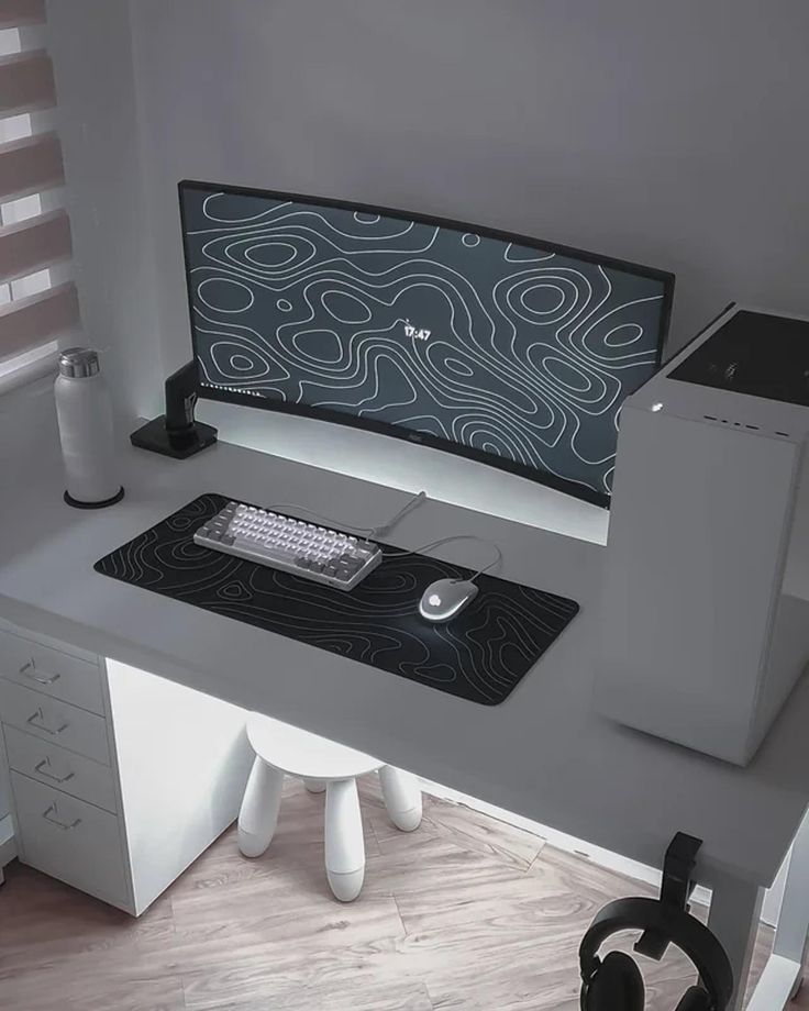 a computer desk with headphones on it and a monitor sitting on top of it