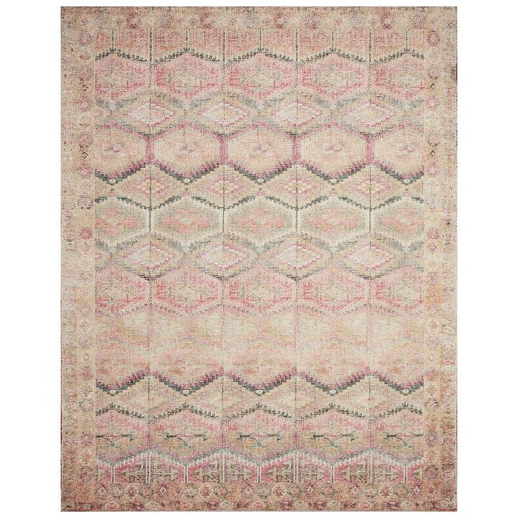 an antique rug with pink and beige colors