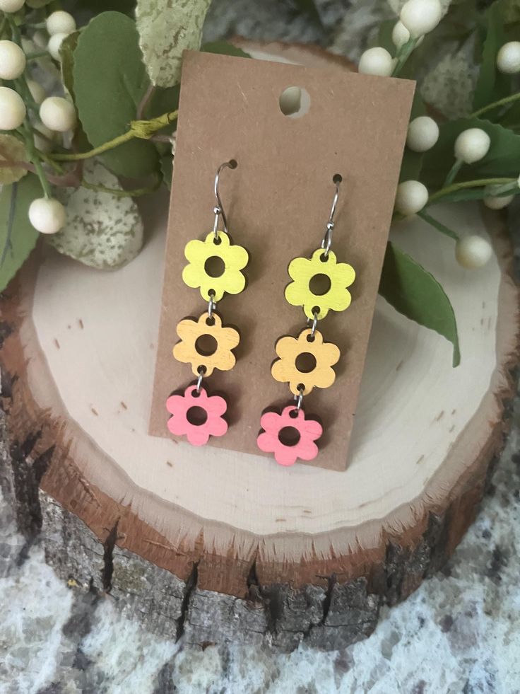 Wood earrings are so trendy right now. And this flower dangle earring is perfect for any season! It is the perfect accessory to complete any outfit. This earring measures 2.5x.5 inches. Choose between 2 color sets.  Great for those who need a hypoallergenic option!  Ships free in the USA Flower Power Wood Earrings, Playful Flower-shaped Spring Earrings, Orange Flower-shaped Earrings For Summer, Multicolor Flower-shaped Artsy Earrings, Yellow Flower-shaped Earrings, Wood Earrings, Simple Earrings, Etsy Earrings Dangle, Cut Flowers