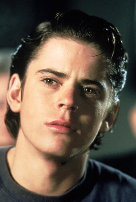 a close up of a person wearing a black shirt and looking at the camera with an intense look on his face