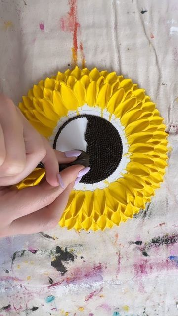 a person using scissors to decorate a sunflower