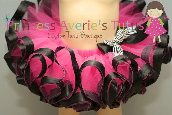 a mannequin wearing a pink and black tutu with a girl on it