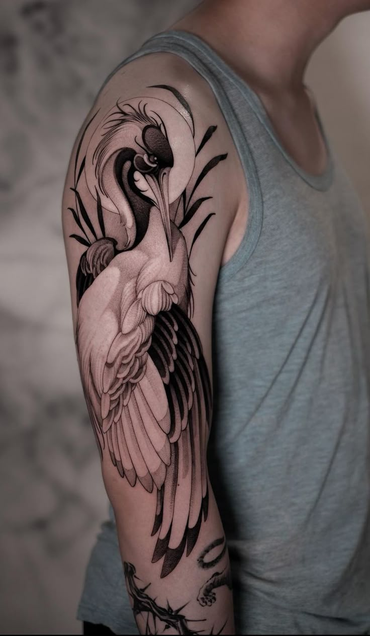 a man with a tattoo on his arm has a large bird in it's beak