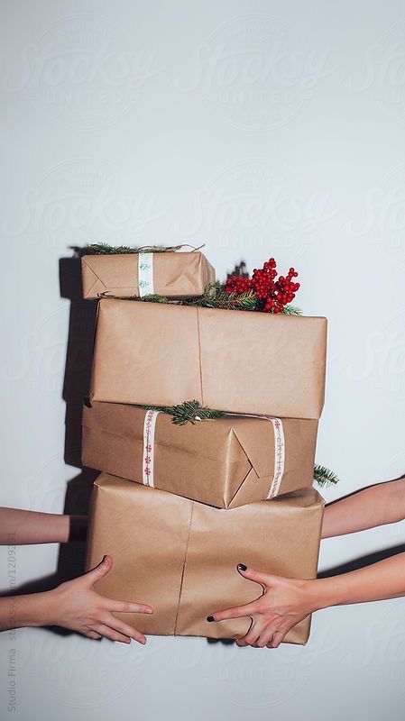 three people holding wrapped presents in their hands