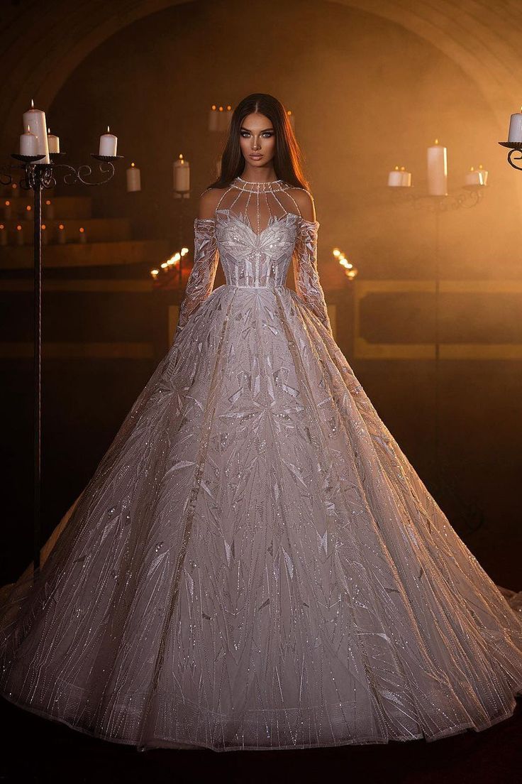 a woman in a wedding dress standing next to candles