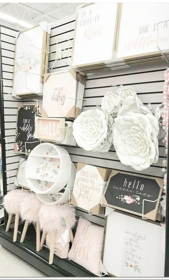 there are many items on the shelves in this store that is decorated with pink and white flowers