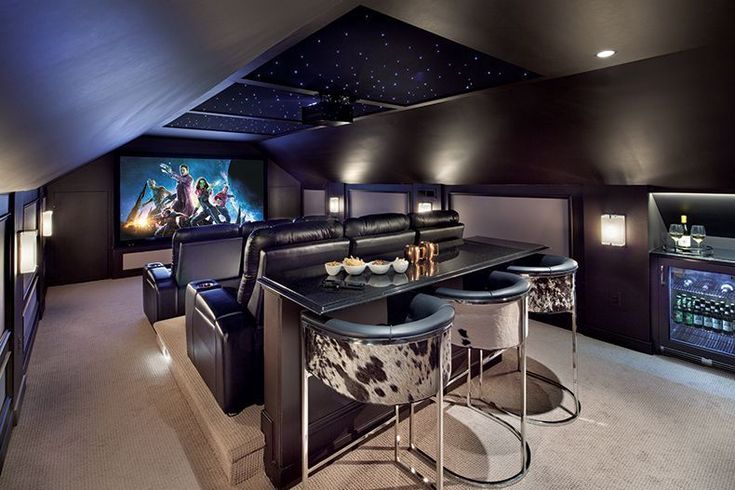 a home theater with two chairs and a bar in the middle of the room,