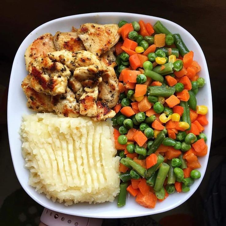 a white plate topped with chicken, mashed potatoes and veggies next to green beans