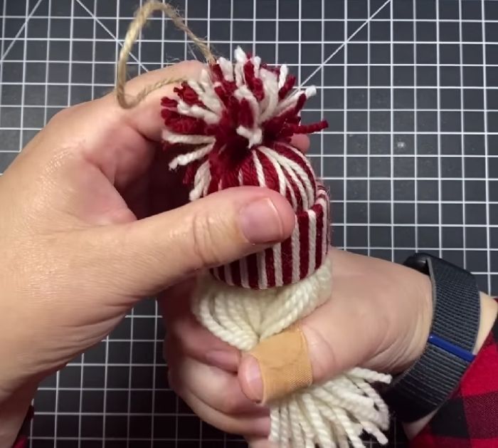 someone is making a christmas ornament out of yarn