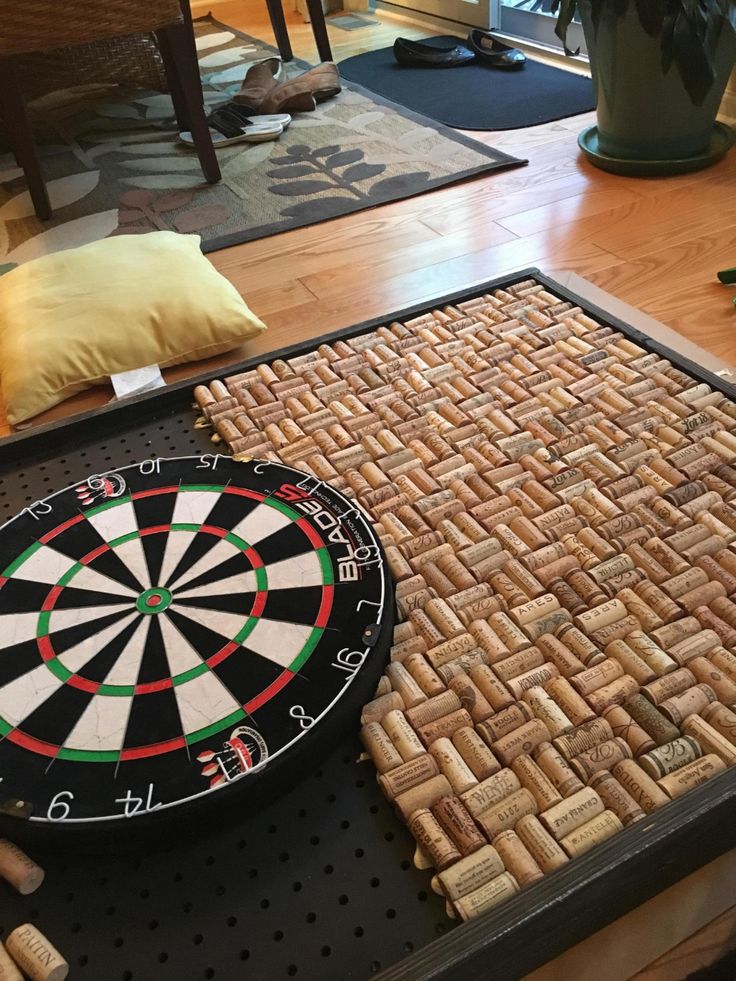 a close up of a table with a dart and some wine corks on it