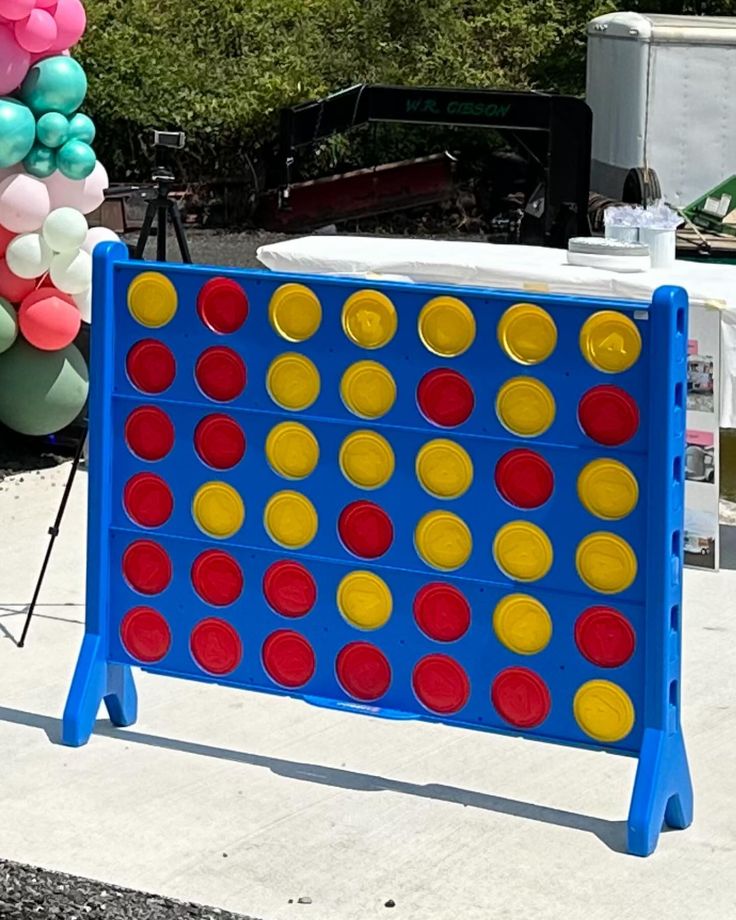 an outdoor game set up with balloons and streamers in the shape of a giant checker board