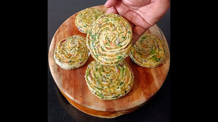 someone is holding up some food on a wooden plate