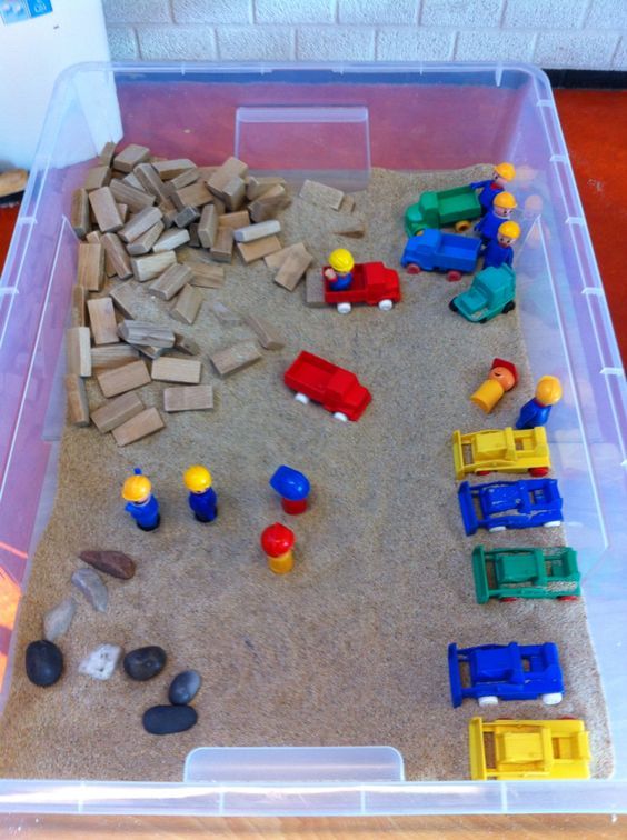 a plastic container filled with toys and sand