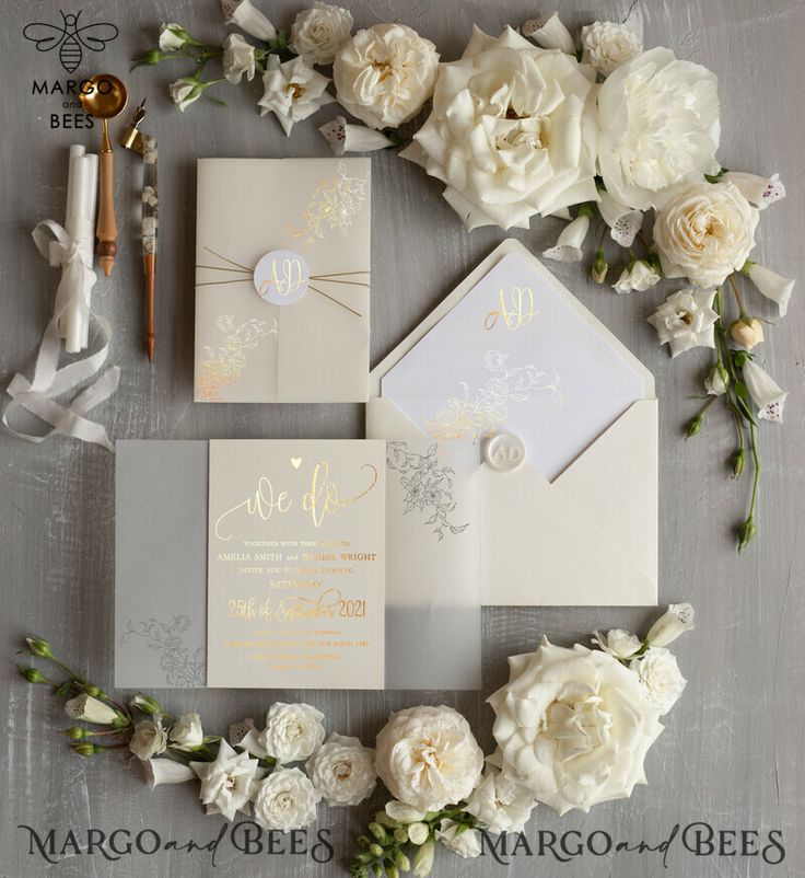 the wedding stationery is laid out with white flowers