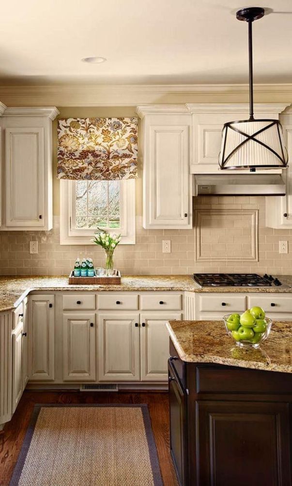 a kitchen with white cabinets and marble counter tops