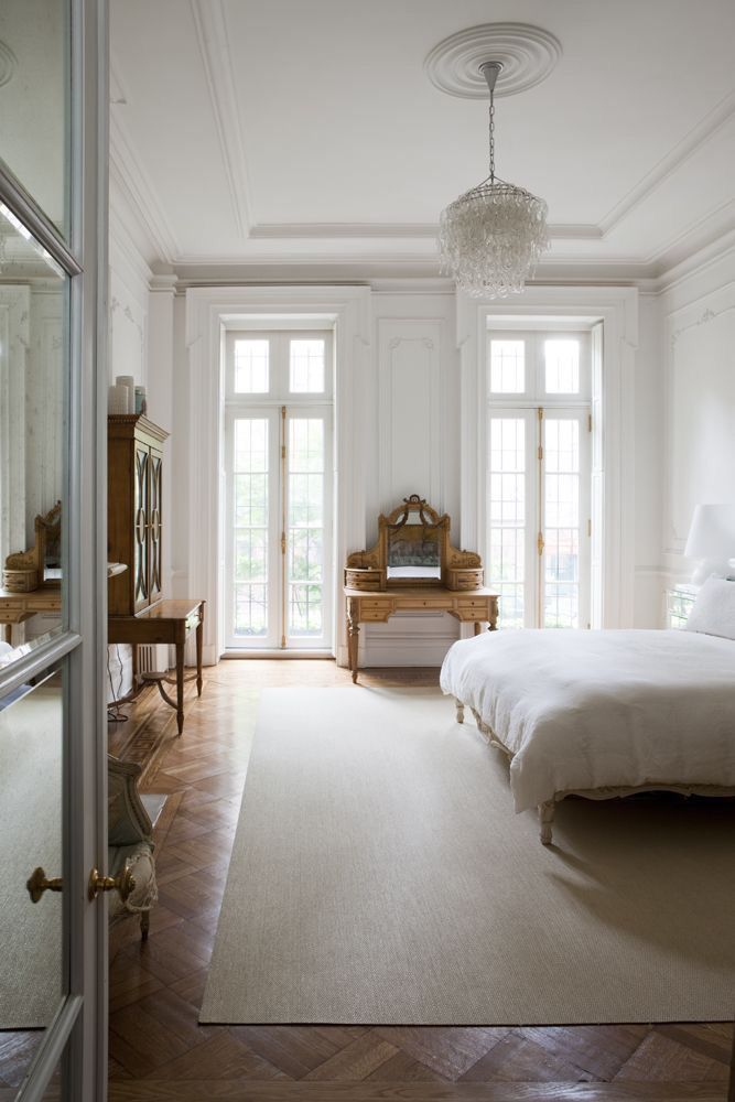 a bedroom with a bed, dresser and mirror on the wall in front of it