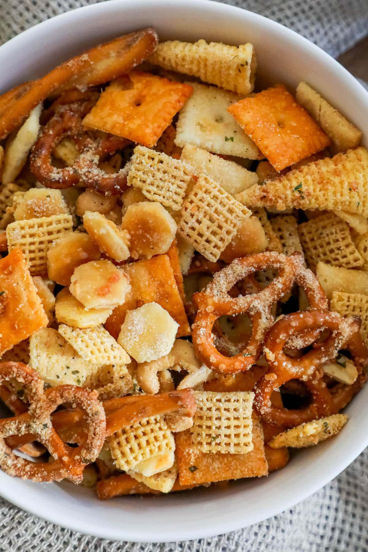 a white bowl filled with cheetos and crackers on top of a table