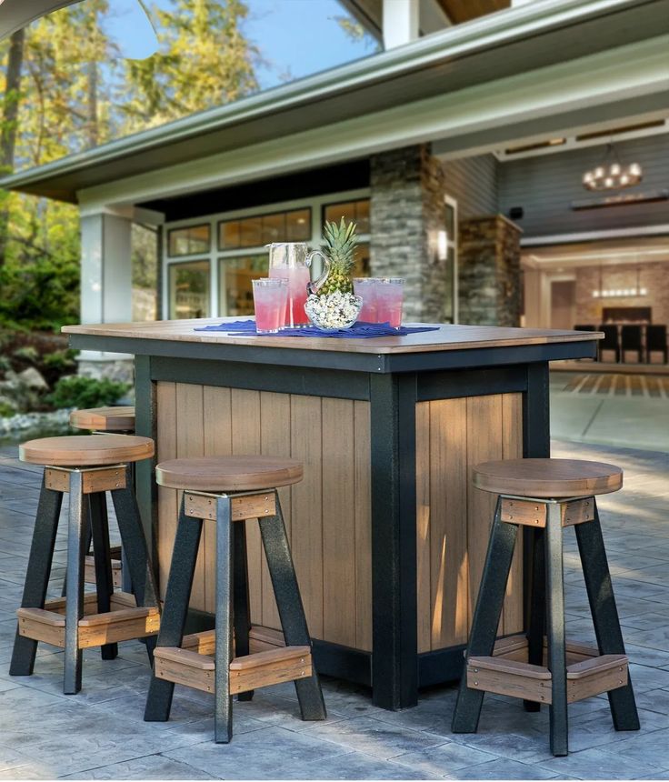 an outdoor bar with three stools next to it