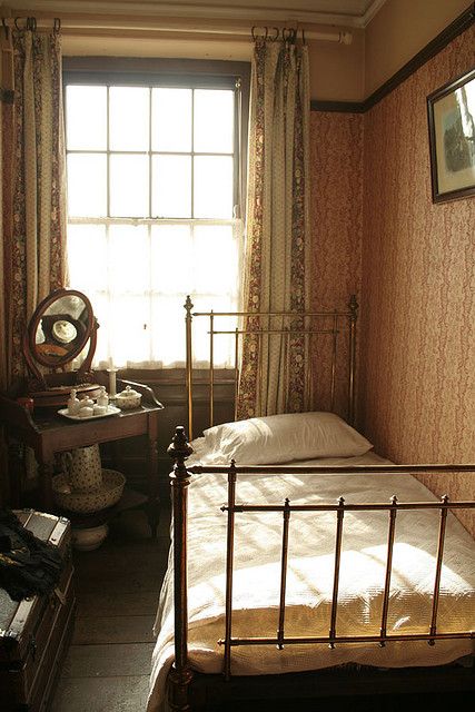 a bedroom with a bed, dresser and window in the corner next to two windows