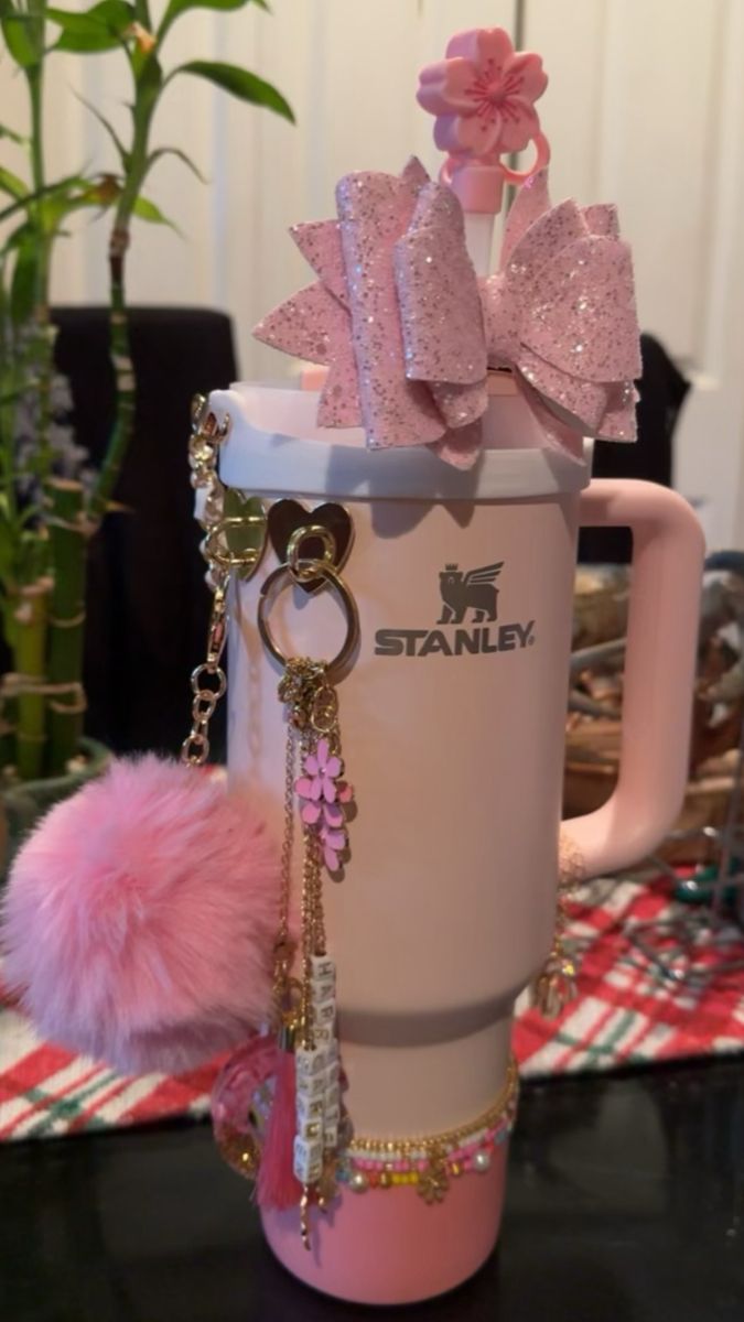 a coffee mug with pink bows and key chains on it