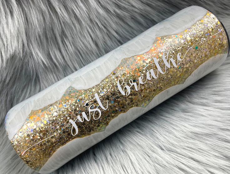 this is an image of a gold glitter tube with the words just breathe on it