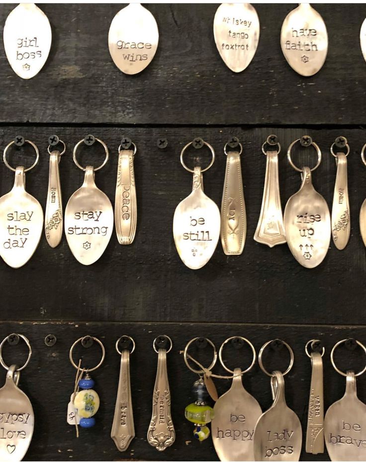 spoons are hanging on the wall with words written on them