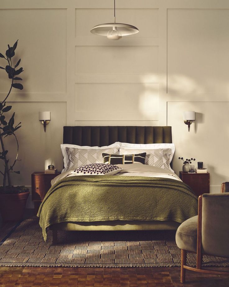 a bedroom with a bed, chair and potted plant