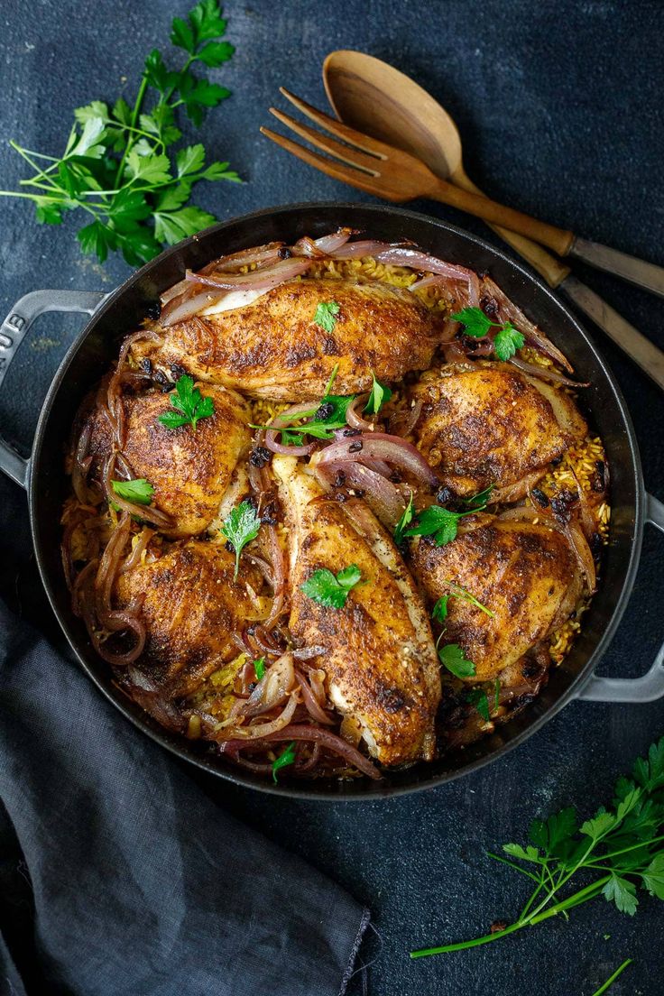 chicken with onions and parsley in a skillet