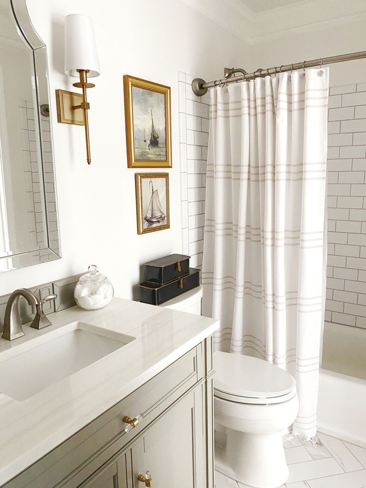 a bathroom with a white toilet sitting next to a sink and a bath tub under a mirror