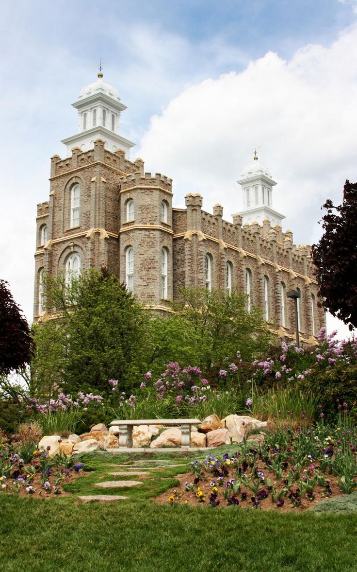 a large building with two towers on top of it's sides and flowers in the foreground