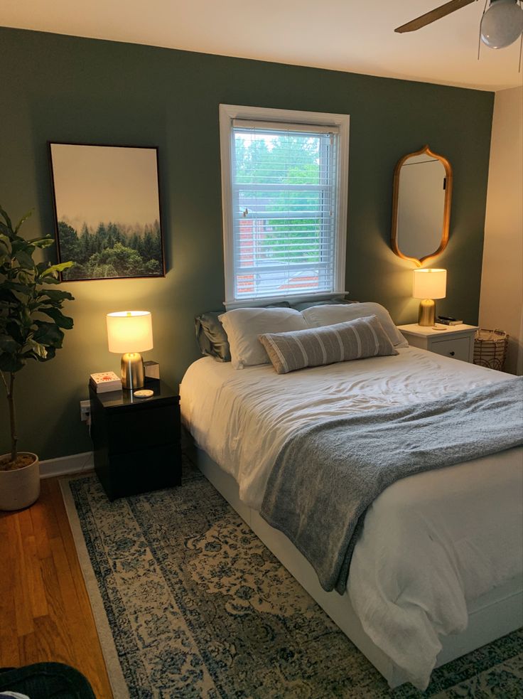 a bedroom with green walls and white bedding