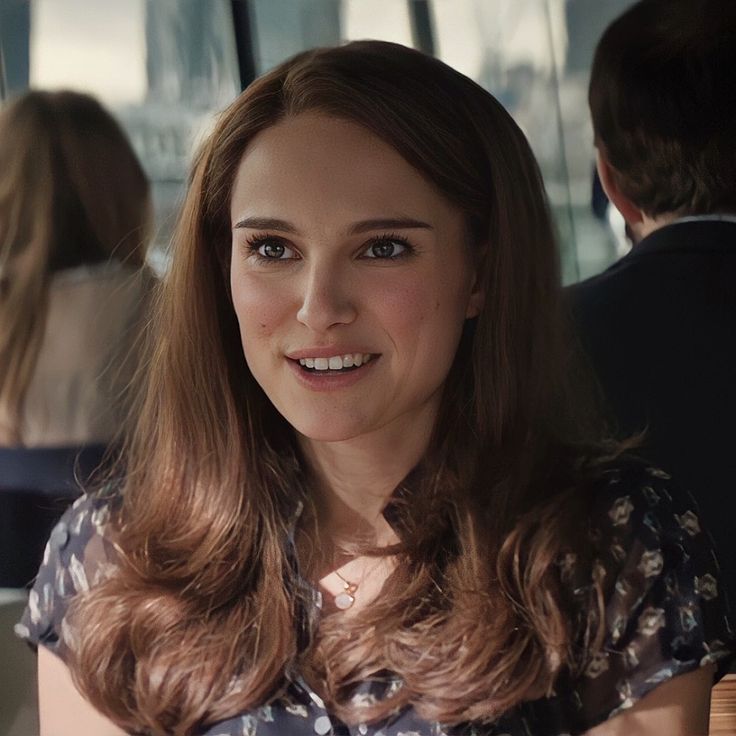 a woman sitting at a table smiling for the camera