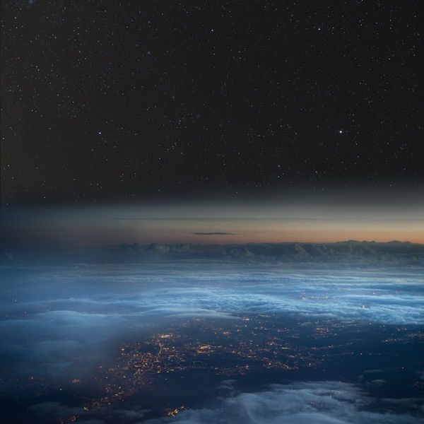 the night sky is filled with stars and clouds as seen from an airplane in flight