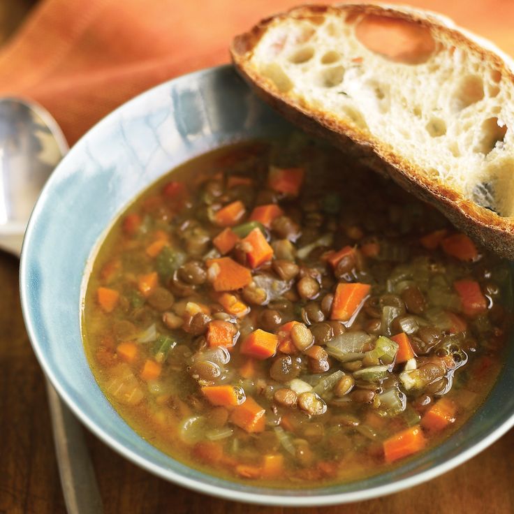 there is a bowl of soup with bread on the side