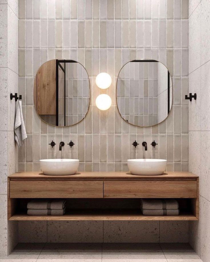 two sinks in a bathroom with mirrors above them