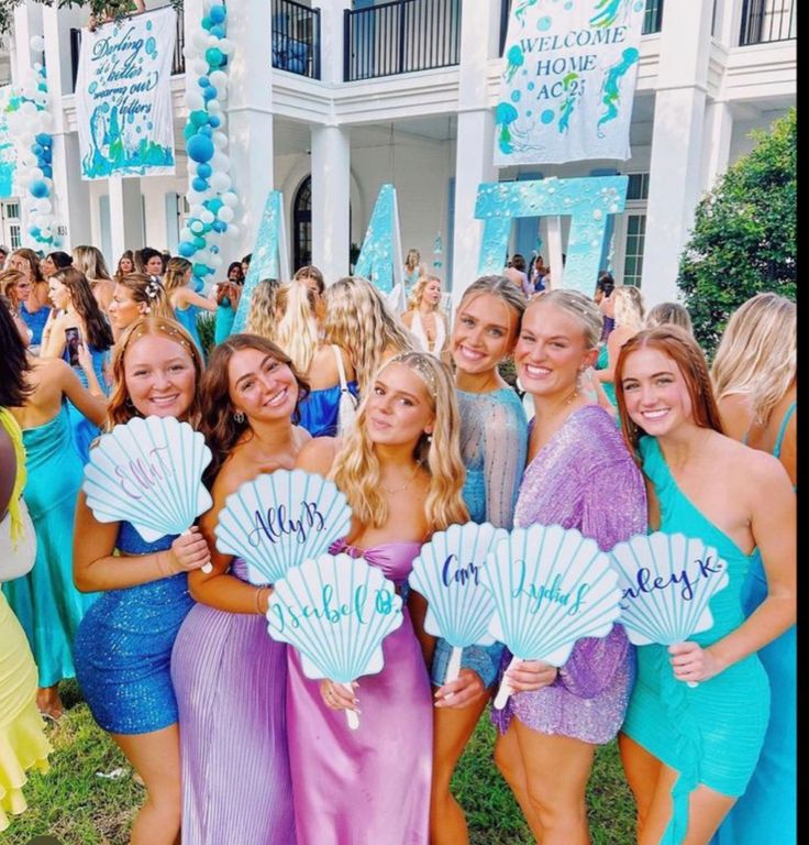 a group of young women standing next to each other in front of a white building