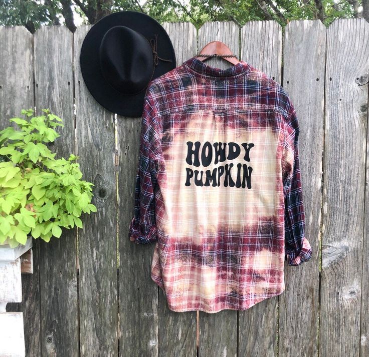 a shirt that says hoddy pumpkin on it next to a hat and potted plant