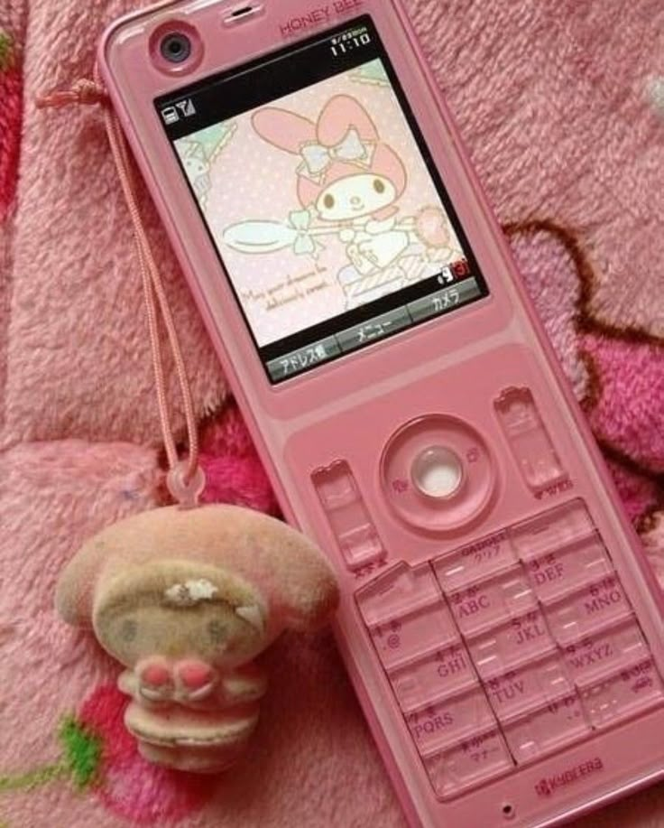 a pink cell phone sitting next to a stuffed animal