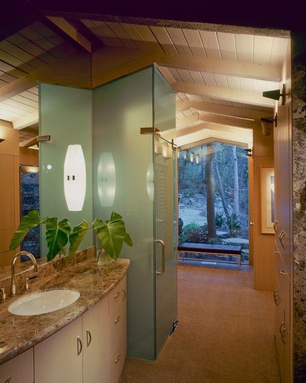 a bathroom with two sinks and a walk in shower next to a large glass door