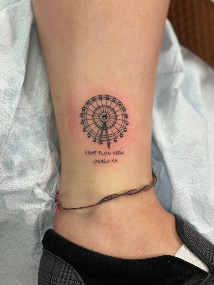 a woman's foot with a tattoo on it that reads, come to the ferris wheel