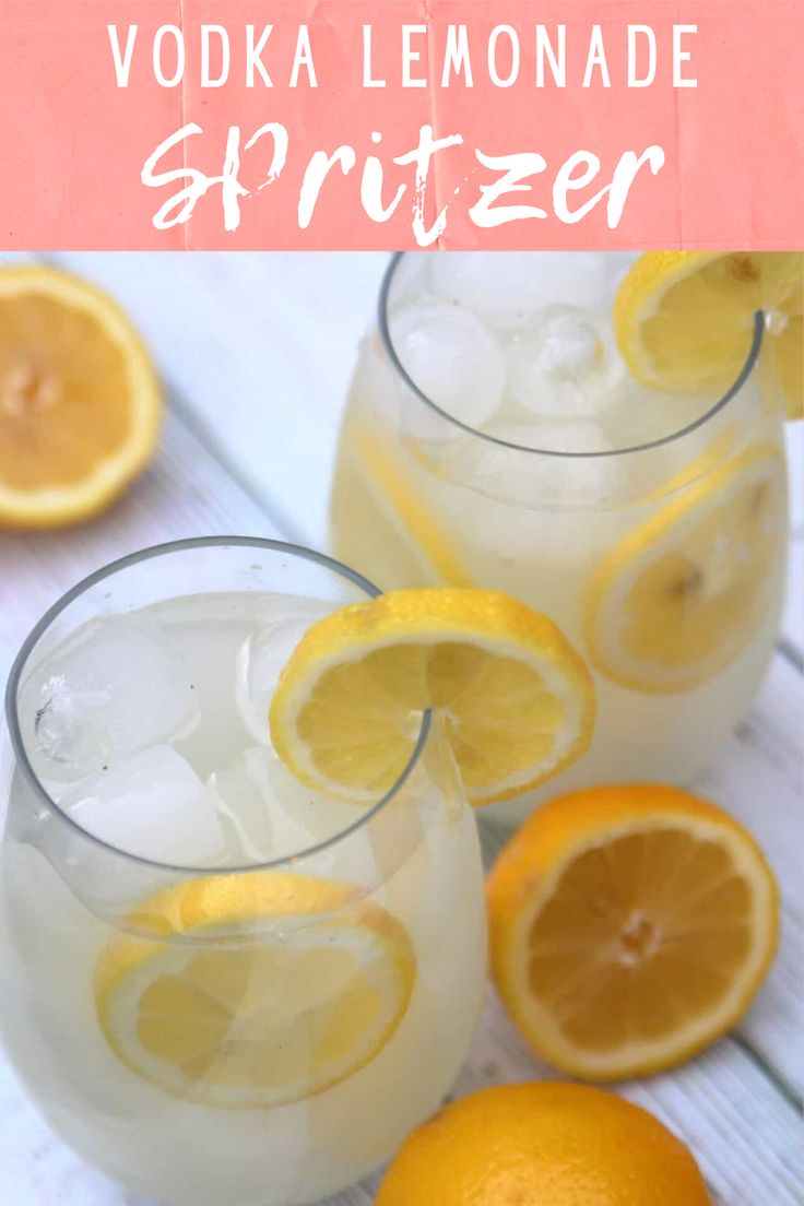 two glasses filled with vodka lemonade spritzer next to sliced oranges on a white table