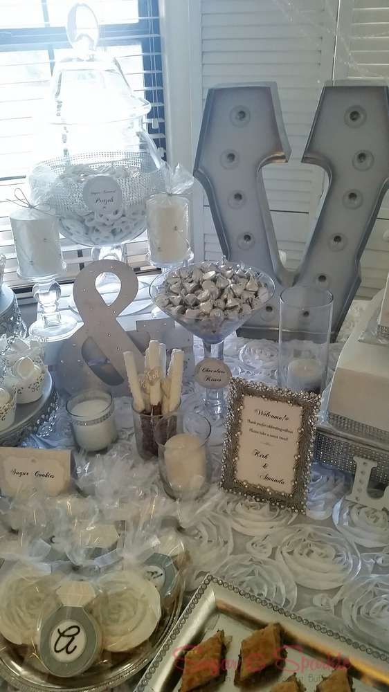 a table topped with lots of cakes and desserts covered in plastic wrapper next to letter shaped letters