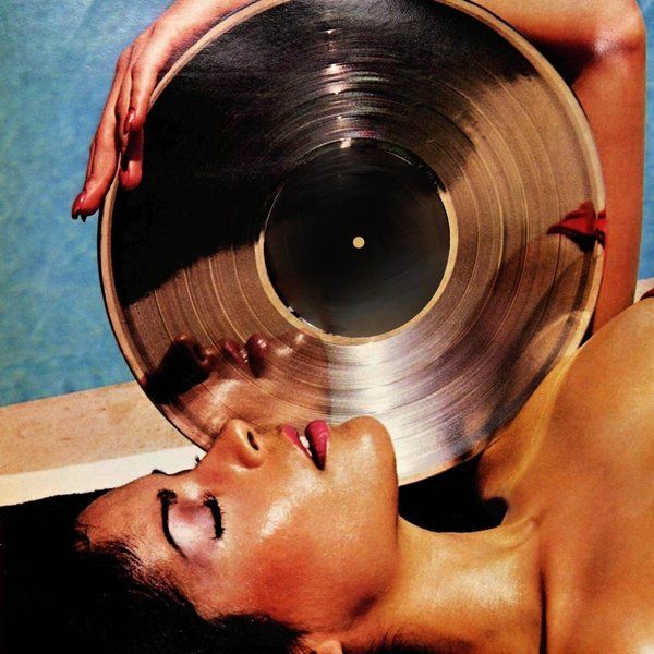 a woman laying on the ground with a record in her hand