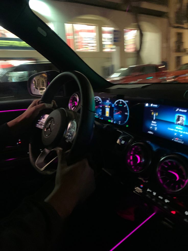 the interior of a car is lit up with neon lights and features electronic dashboard controls