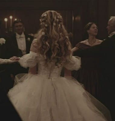 a woman in a white wedding dress dancing with other people