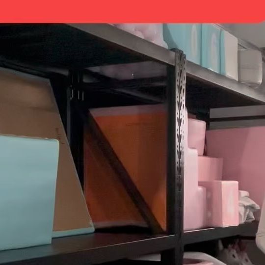 there is a shelf that has many items on it in the room with pink walls