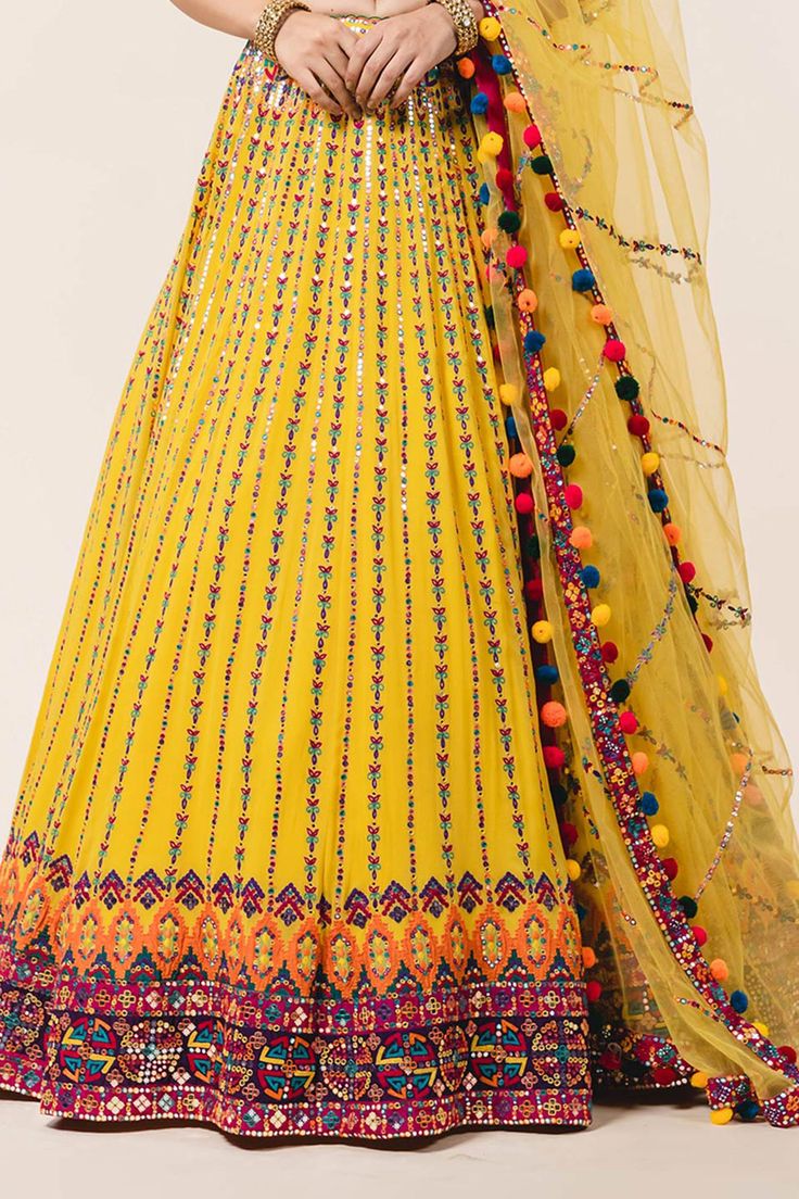 Yellow lehenga with attached cancan, all-over multicolored applique work, sequin embellishments and drawstring with tassels. Comes with sweetheart neckline padded blouse and tulle dupatta.
Component: 3
Embroidered
Neckline: Sweetheart
Sleeve Length: Sleeveless
Fabric: Lehenga and Blouse: Georgette; Dupatta: Tulle 
Color: Yellow
Applique, resham, sequin and patra embroidery
Embroidered blouse with cutwork and pompoms at the hem
Tie-up at the back with pompoms
Embroidered dupatta - Aza Fashions Lehenga And Blouse, Tulle Embroidery, Yellow Lehenga, Applique Work, Georgette Dupatta, Padded Blouse, Lehenga Blouse, Embroidered Dupatta, Embroidered Neckline