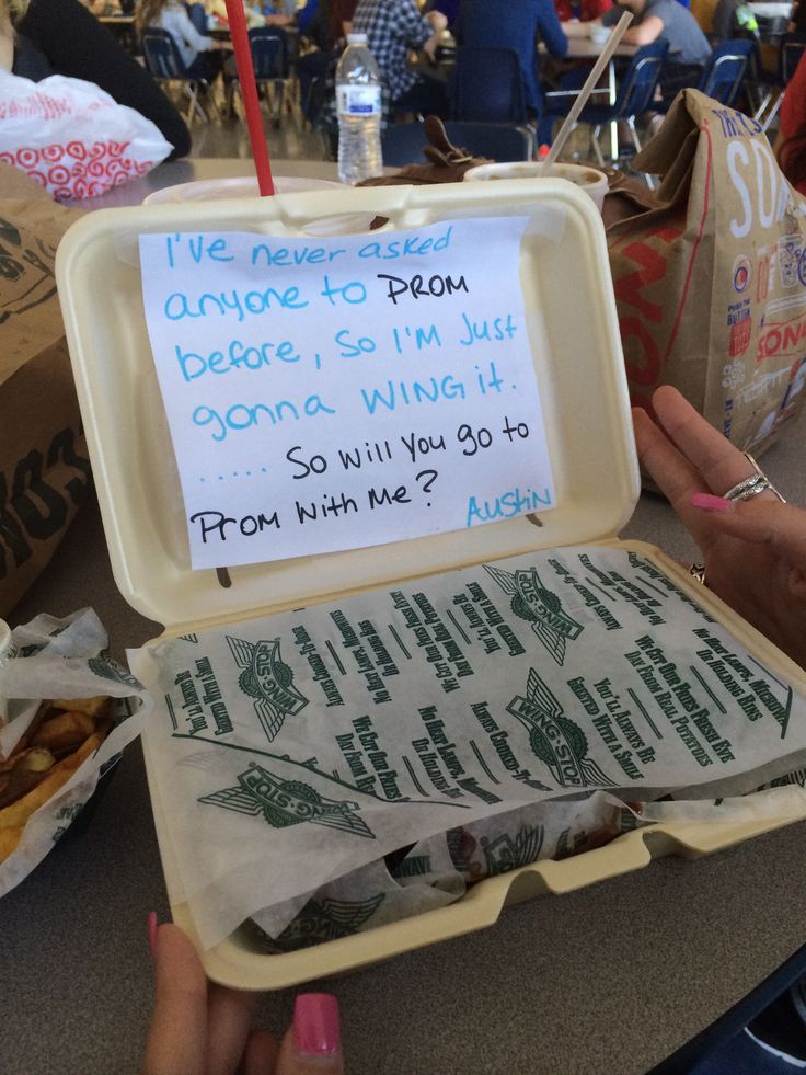 an open lunch box with writing on it and someone's hand holding the lid