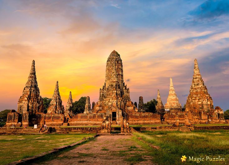 the sun is setting in front of an ancient building with many spires on it