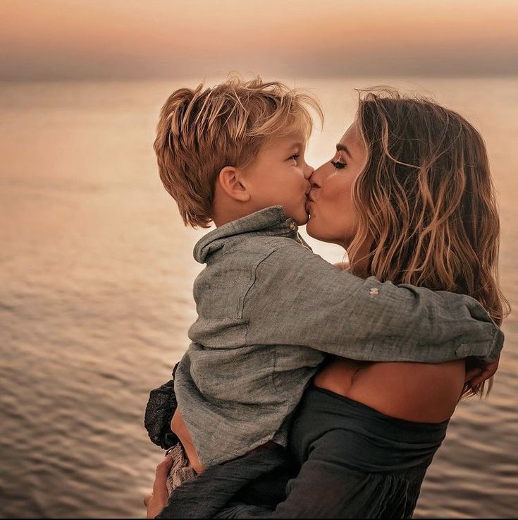 a mother kissing her son on the cheek